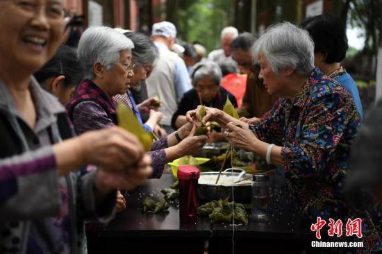  资料图：5月25日，重庆歌乐山的200余位老人一起包粽子，迎接端午佳节的来临。 中新社记者 陈超 摄